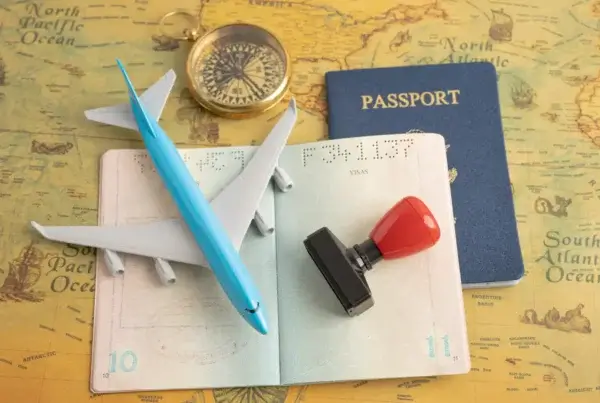 A passport, visa stamp, and airplane on a map, showing travel and Malaysia student visa requirements.
