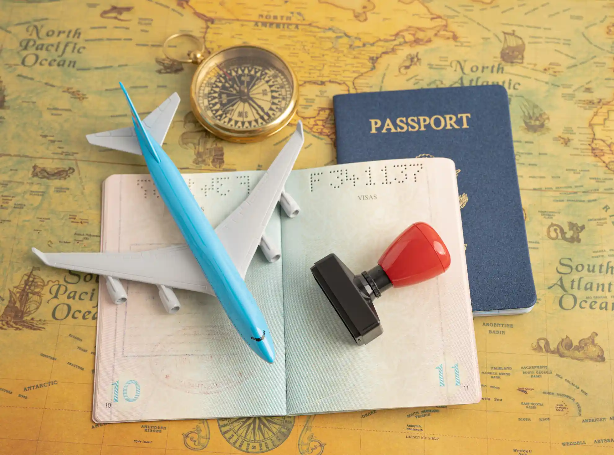 A passport, visa stamp, and airplane on a map, showing travel and Malaysia student visa requirements.