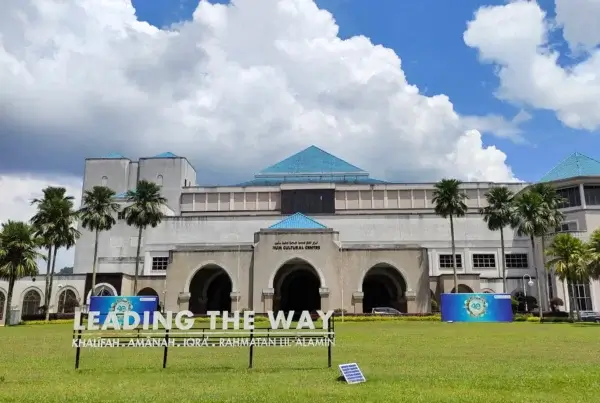 A building stands in front of a green field, representing the IIUM admission process.
